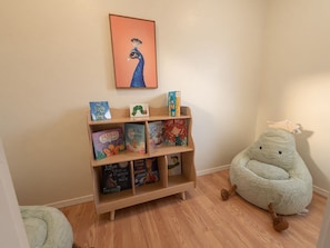 Ein Kinderregal mit Büchern und einem Stofftier.