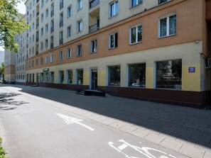 Ein mehrstöckiges Gebäude mit einem Geschäftsraum im Erdgeschoss, großen Fenstern und einem gut ausgebauten Fußweg.