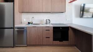 A modern kitchen with wooden cabinets, stainless steel appliances, and a built-in dishwasher.
