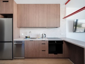 A modern kitchen with wooden cabinets, stainless steel appliances, and a built-in dishwasher.