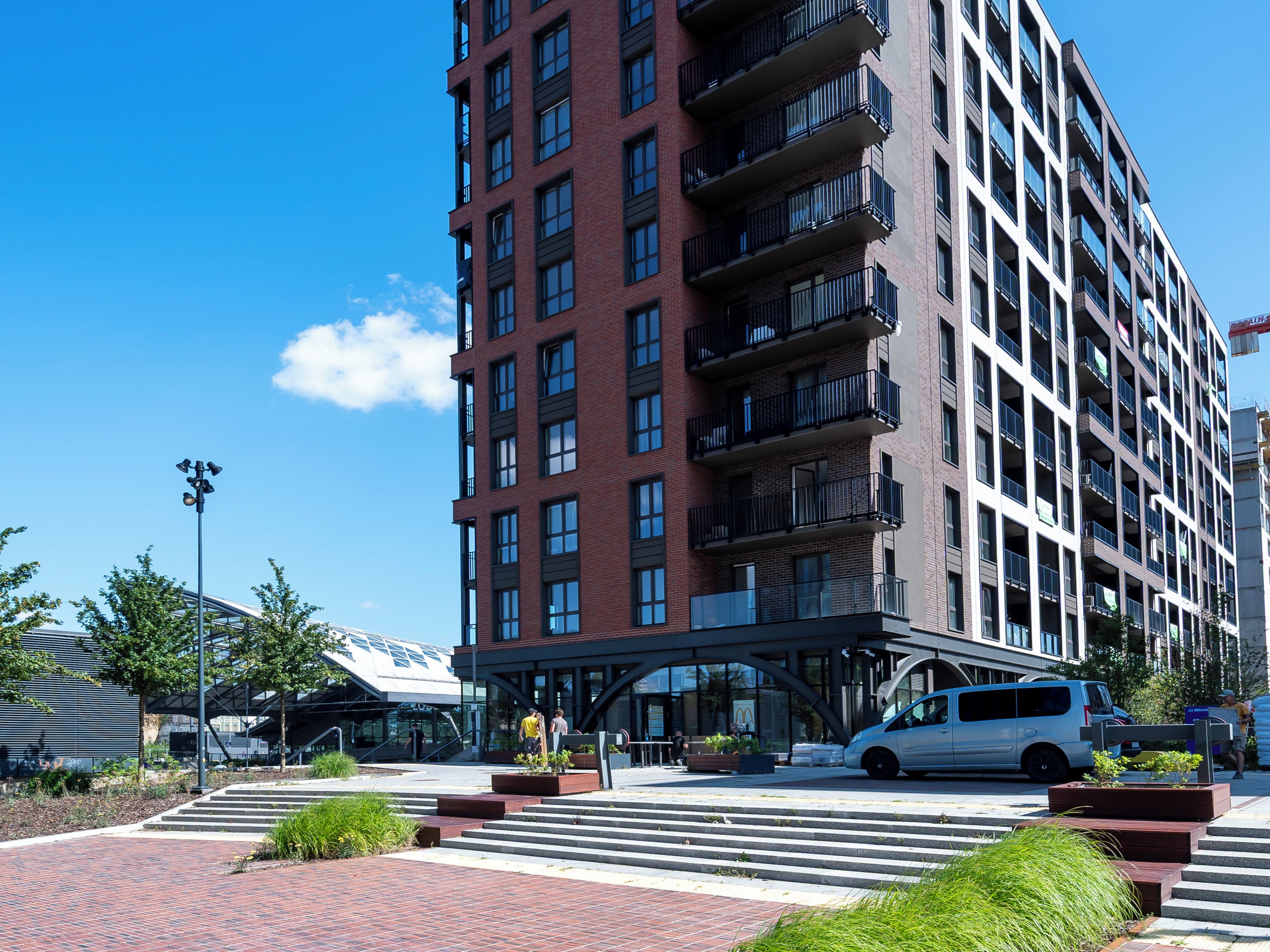 A multi-story building with a modern architectural design, featuring balconies and large windows.