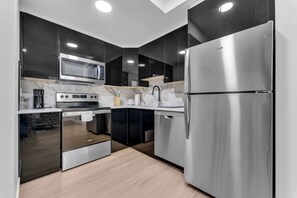 A modern kitchen with stainless steel appliances, a microwave, and a dishwasher. - Modern 2BR Suite | Near YEG Airport & Amenities (Edmonton)