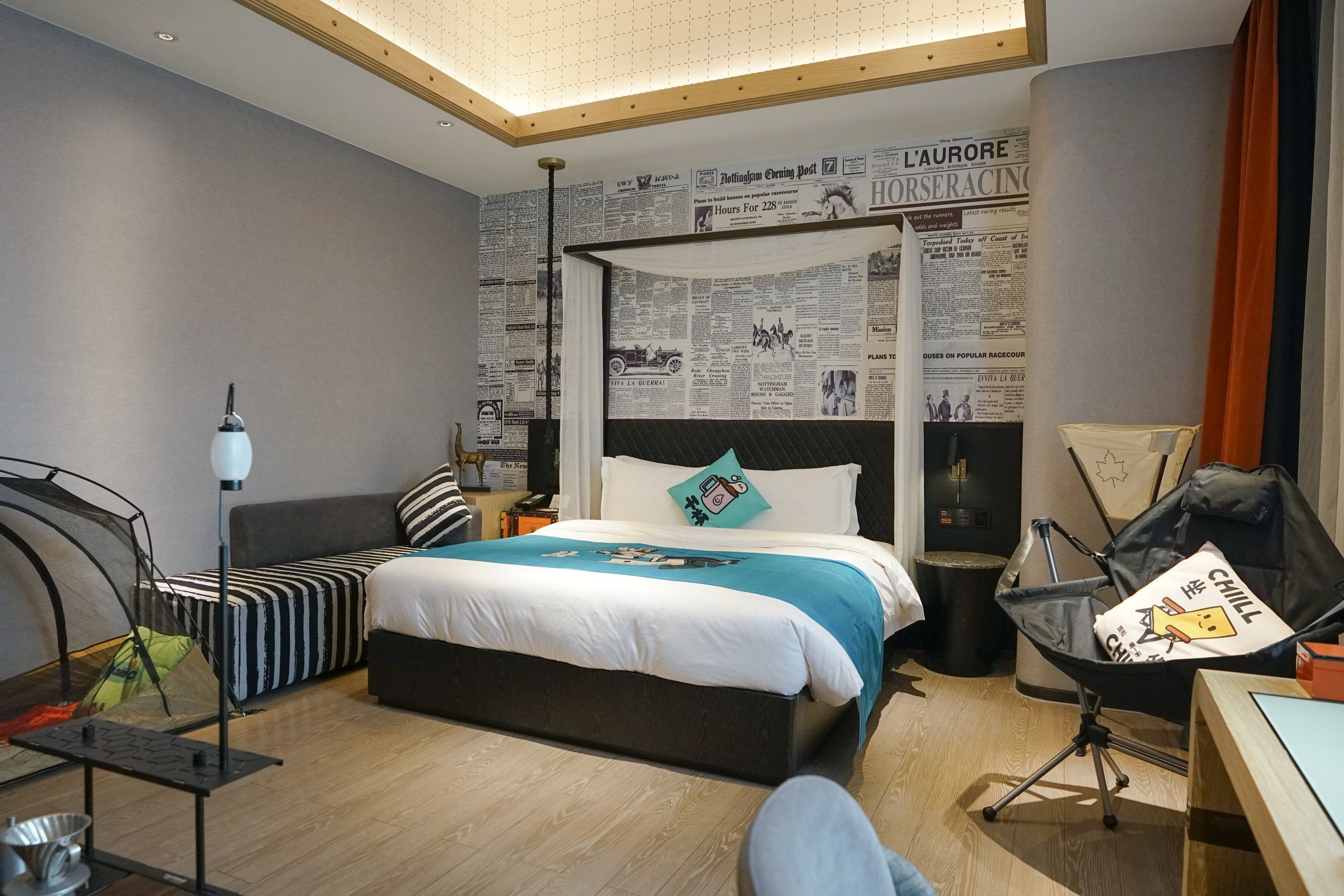 A modern hotel room with a large bed, a desk, and a chair.