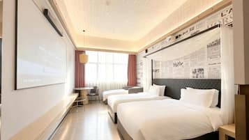 A hotel room with two beds, a desk, a chair, a TV screen, and a large window with curtains.
