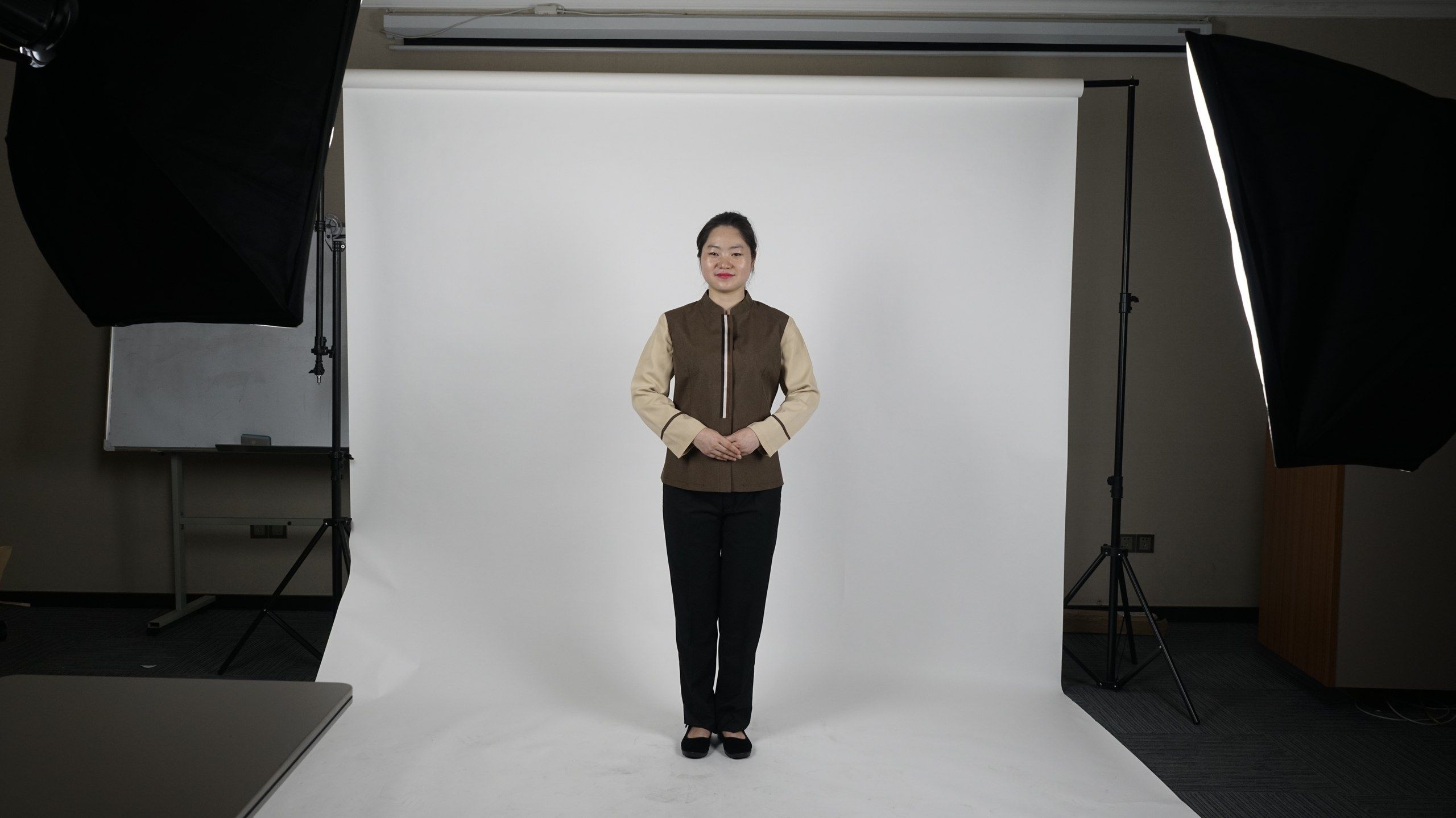 A person standing in a studio with professional lighting equipment.
