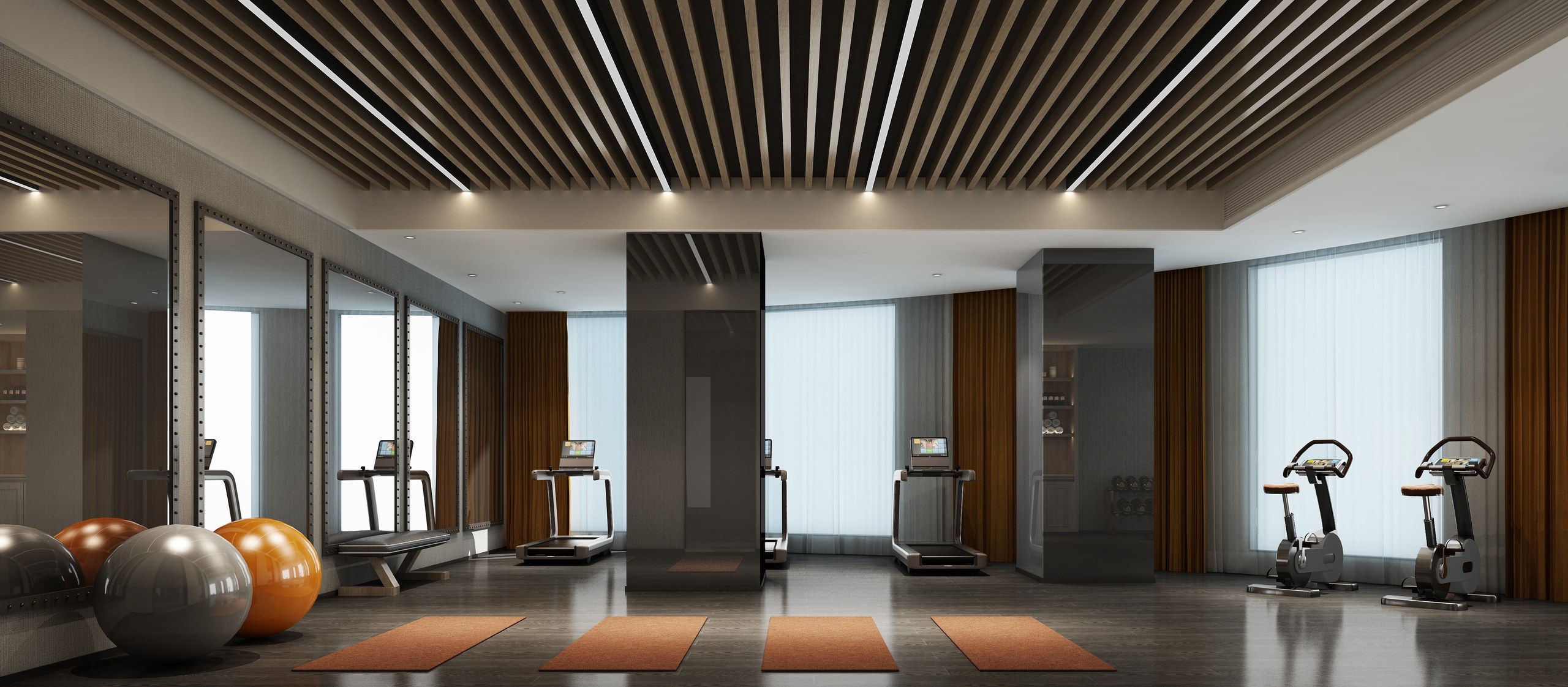 Een moderne fitnessruimte met loopbanden, elliptische trainers en fitnessballen.