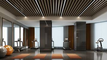 Een moderne fitnessruimte met loopbanden, elliptische trainers en fitnessballen.
