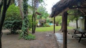 A covered outdoor area with a picnic table and a wooden structure. - Cabañas Refugio LAS ACEQUIAS (Tanti)