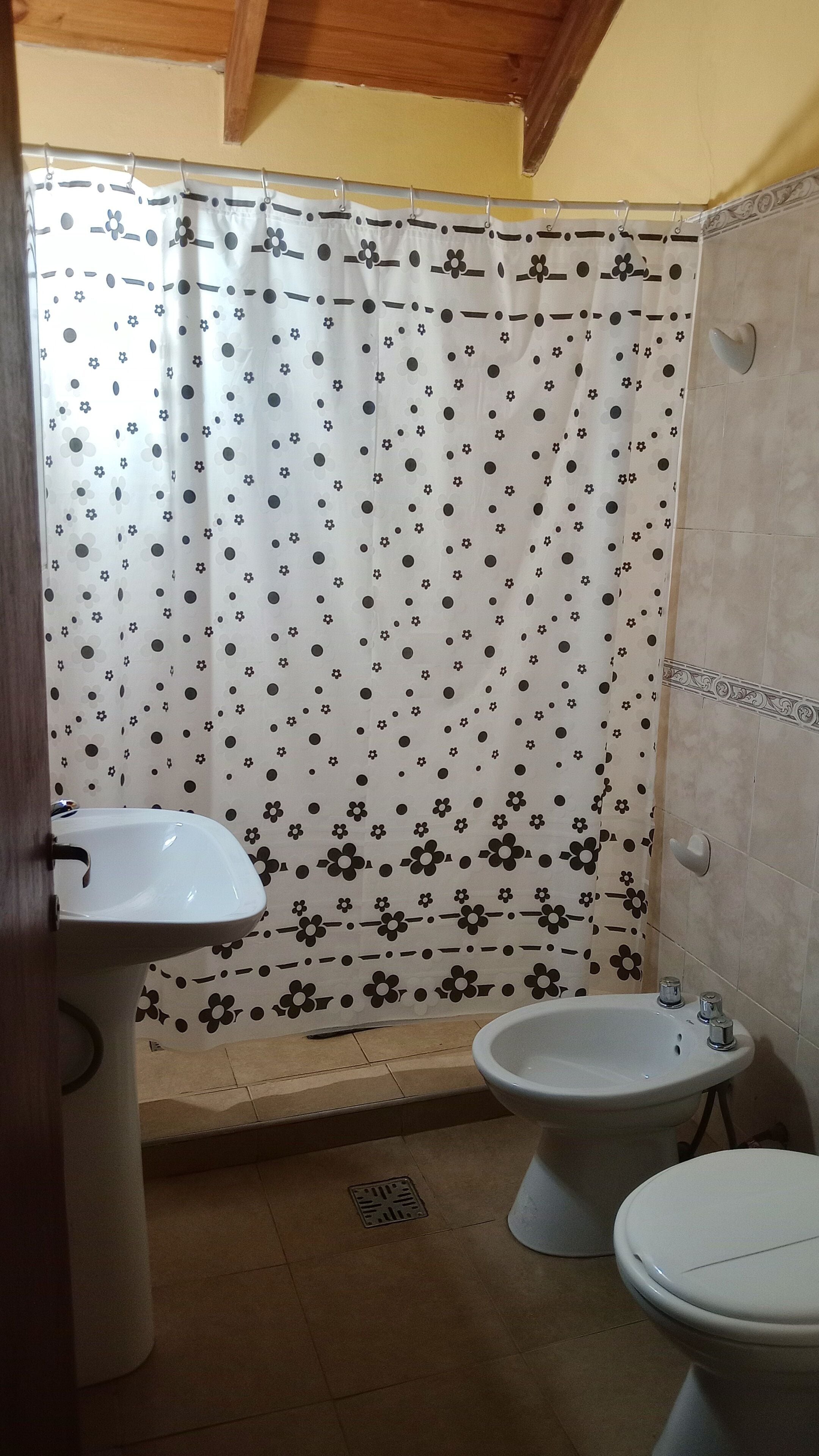 Ein Badezimmer mit Duschvorhang, Waschbecken und Toilette.