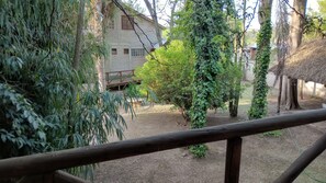Une clôture en bois rustique, un bâtiment en pierre et une variété de plantes.