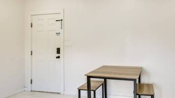 Una habitación con una puerta blanca, una mesita y dos mesitas auxiliares a juego.