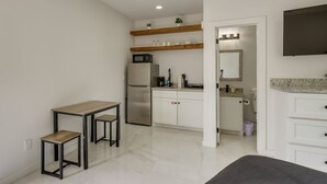 A compact kitchen with a refrigerator, microwave, and a small dining area with stools. - #8 | South Padre Studio | Pool | Walk 2 Beach (South Padre Island)