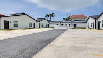 A row of modern, single-story buildings with a paved walkway in between.