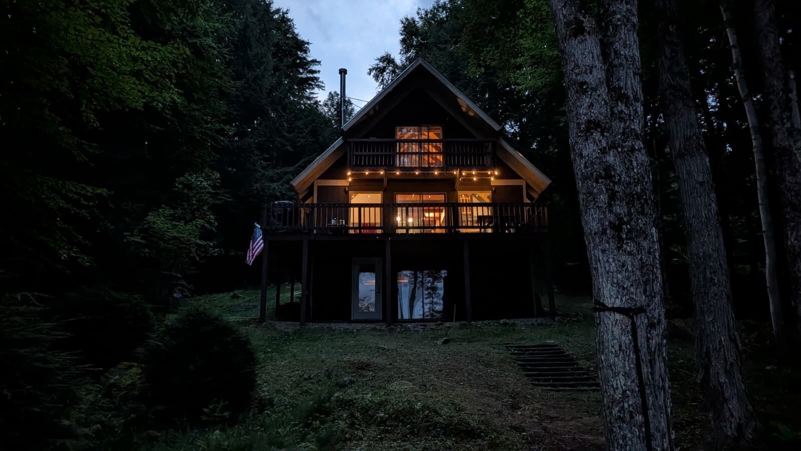 Eine Holzhütte mit Balkon, Tür und einer US-amerikanischen Flagge.
