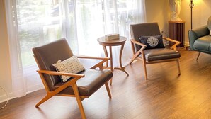 Une pièce comprenant deux fauteuils en cuir, une petite table en bois et une lampe.