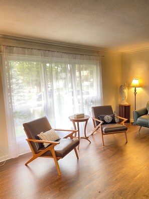 Een kamer met twee leren fauteuils, een klein houten tafeltje en een lamp.