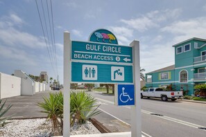 A beach access sign for Gulf Circle Beach with symbols for restrooms and wheelchair access.