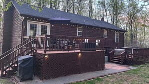 Une cabane en bois dotée d’une terrasse, d’un espace salon extérieur et d’une zone abritée.