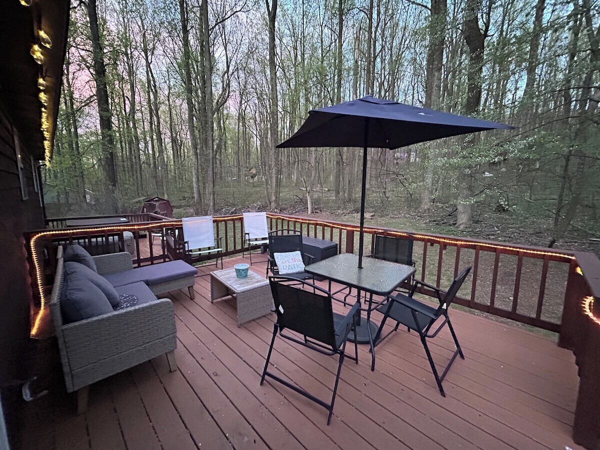 A deck with outdoor furniture, including a sofa, chairs, and a table, surrounded by a railing.