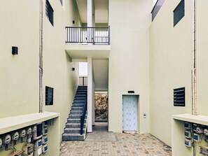 A multi-level interior with a central staircase, a light blue door, and electrical panels on the walls. - Elisabeth Beach House near Mambo Beach (Willemstad)