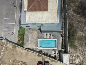 A residential building with a rooftop terrace, a swimming pool, and a parking area. - Elisabeth Beach House near Mambo Beach (Willemstad)