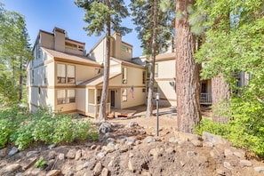 A multi-story building with a wooden exterior, surrounded by trees and a rocky landscape. - 3-bedroom condo in fabulous Kings Beach close to Beach and Ski Resorts. (Kings Beach)