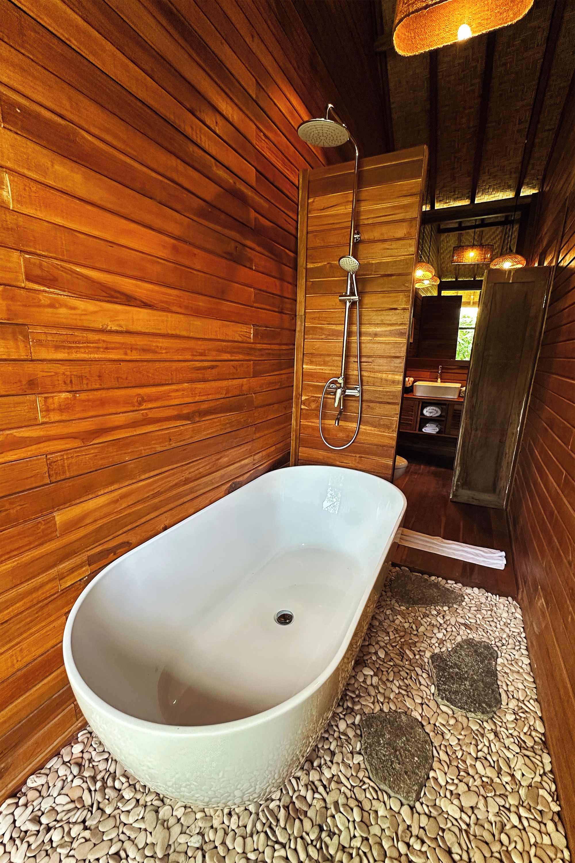 Un interior de madera con una bañera, ducha y lavamanos.