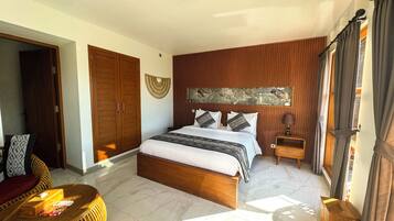 Quarto com cama, guarda-roupa de madeira e cadeira de vime.