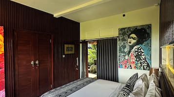 Quarto com uma cama grande, um guarda-roupa de madeira e um quadro na parede.