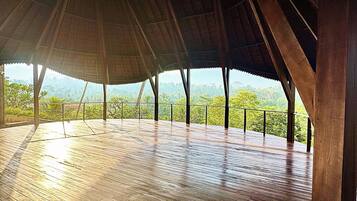 Una terraza de madera abierta con vistas a un paisaje montañoso.