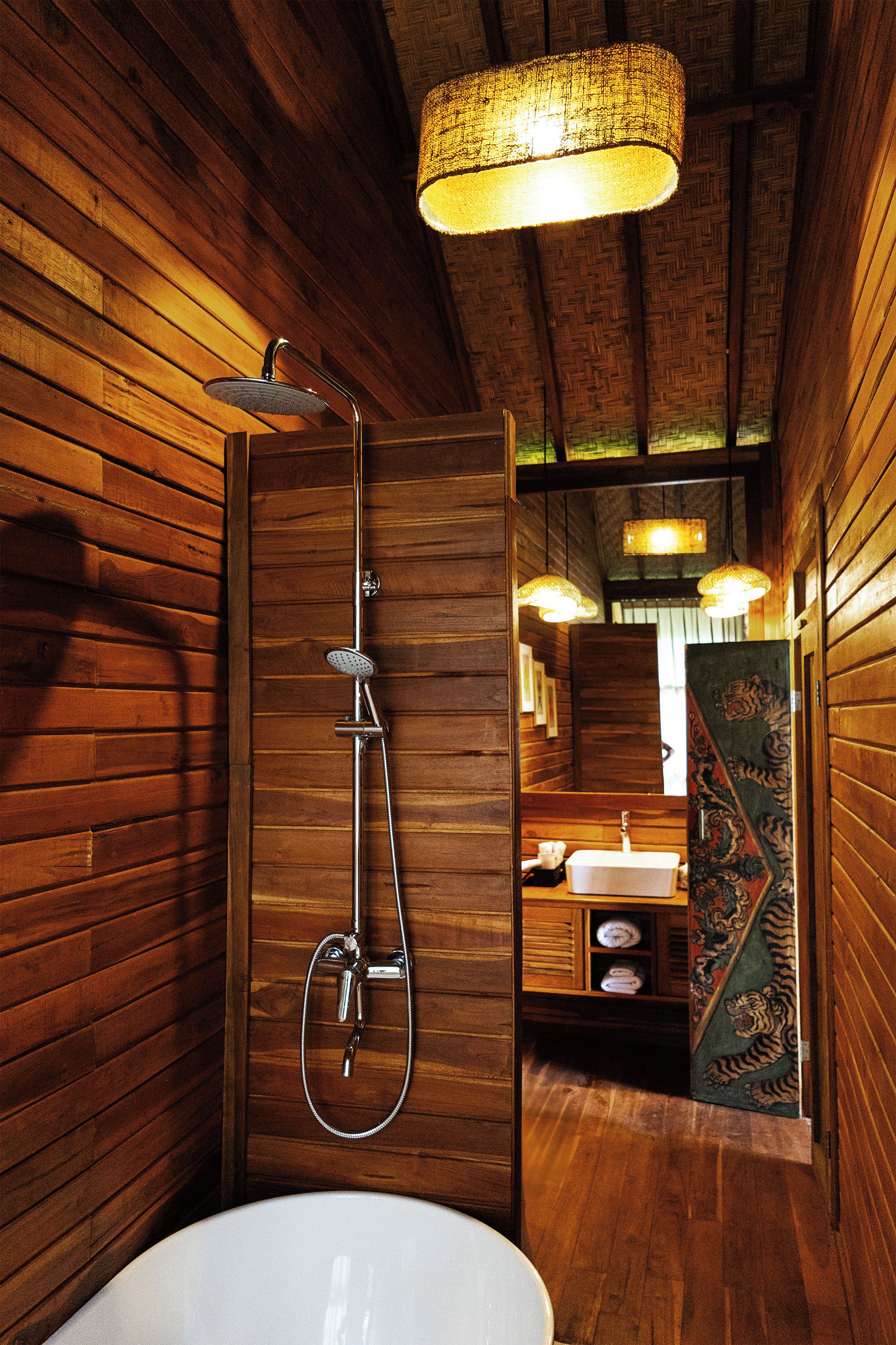Un interior de madera con ducha, lavabo y espejo.