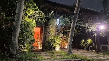 A building with a stone facade, a lit entrance, and a sign with a circular logo.
