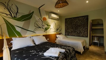 Habitación de hotel con dos camas, un mural floral grande, un cuadro abstracto moderno y una lámpara colgante.