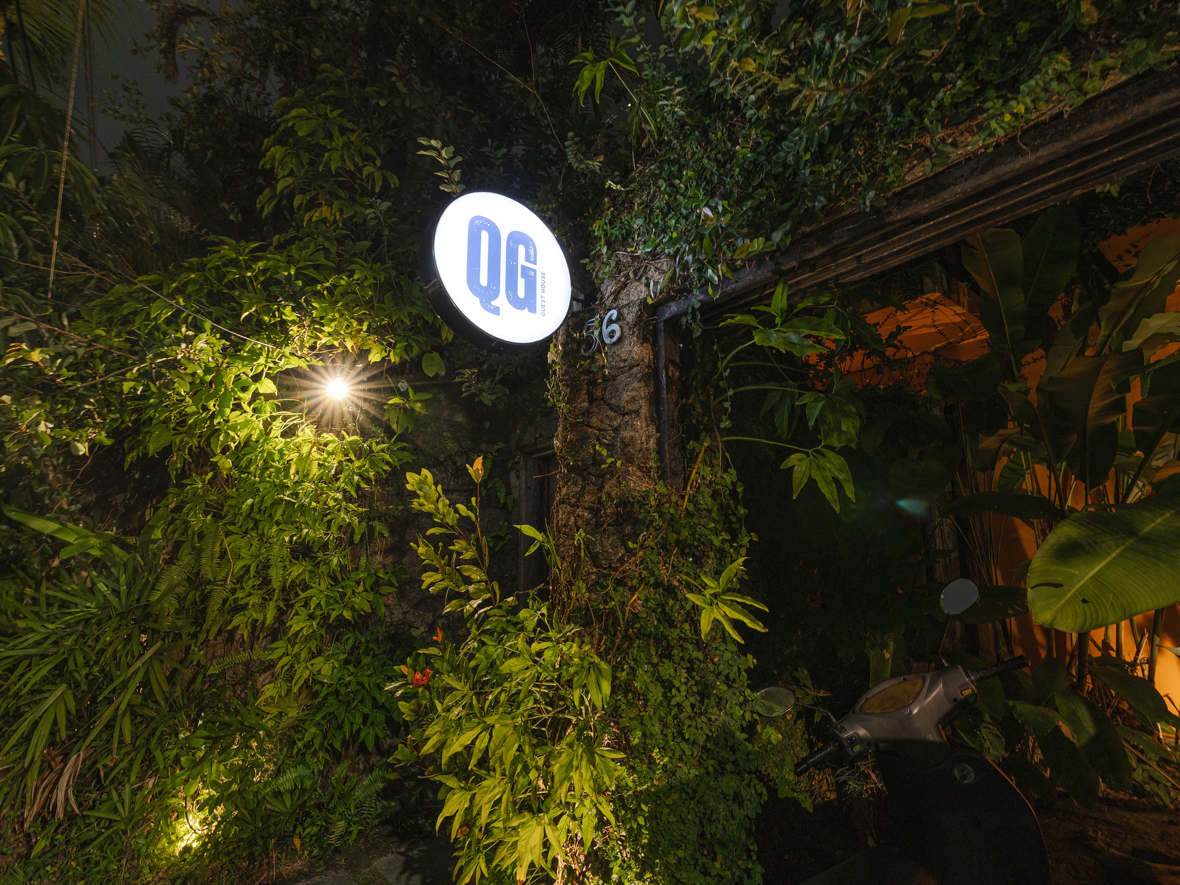 A sign with 'OG' and a number '16' in a lush, green environment.