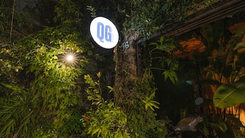 A sign with 'OG' and a number '16' in a lush, green environment.