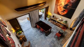 Un comedor espacioso con techo alto, una mesa grande y vistas al patio exterior.