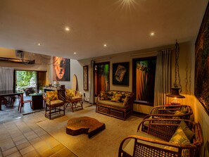 A spacious living area with a sofa, chairs, a coffee table, and artwork on the walls.