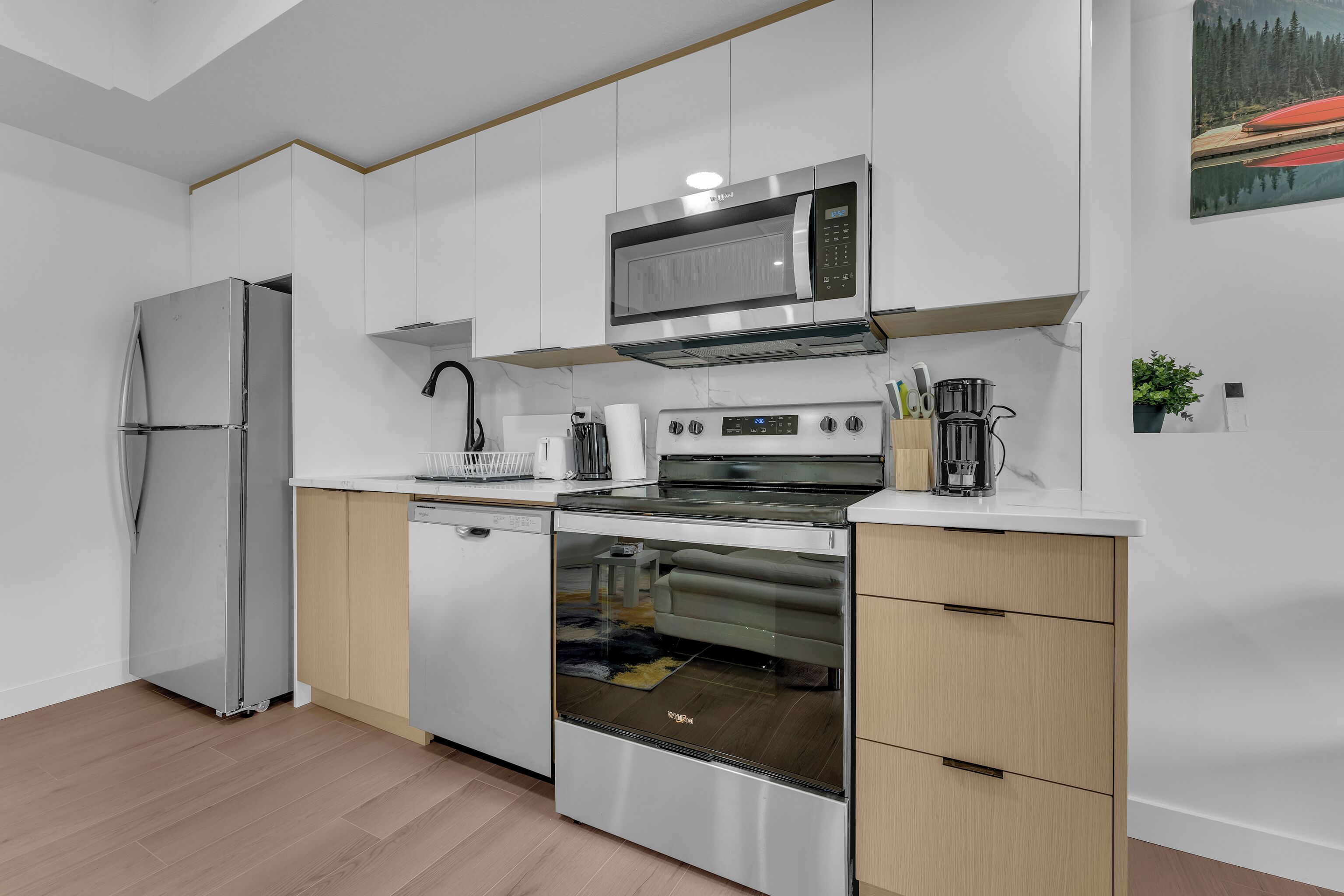 Una cocina moderna con electrodomésticos de acero inoxidable, armarios de madera y horno empotrado.