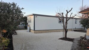 A building with a gravel driveway and a small tree.