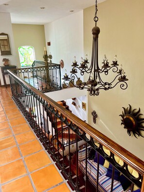 A staircase with a wrought iron railing and a chandelier. - Casa Serena Vallarta/Perfect 3-BR house with AC, Private Pool & Near the Beach. (Puerto Vallarta)