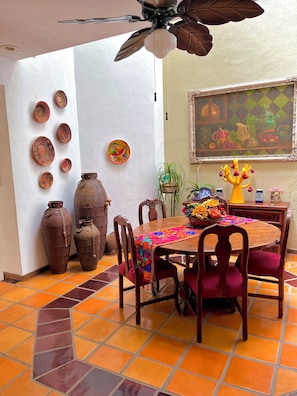 A dining area with a wooden table, chairs, and a ceiling fan. - Casa Serena Vallarta/Perfect 3-BR house with AC, Private Pool & Near the Beach. (Puerto Vallarta)