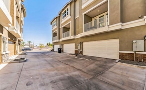 A residential building with multiple garage doors, a paved driveway, and a clear sky. - NO FEES! Downtown Studio-style L/O, Night Security (Mesa)