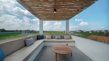 A covered outdoor seating area with a view of the landscape.