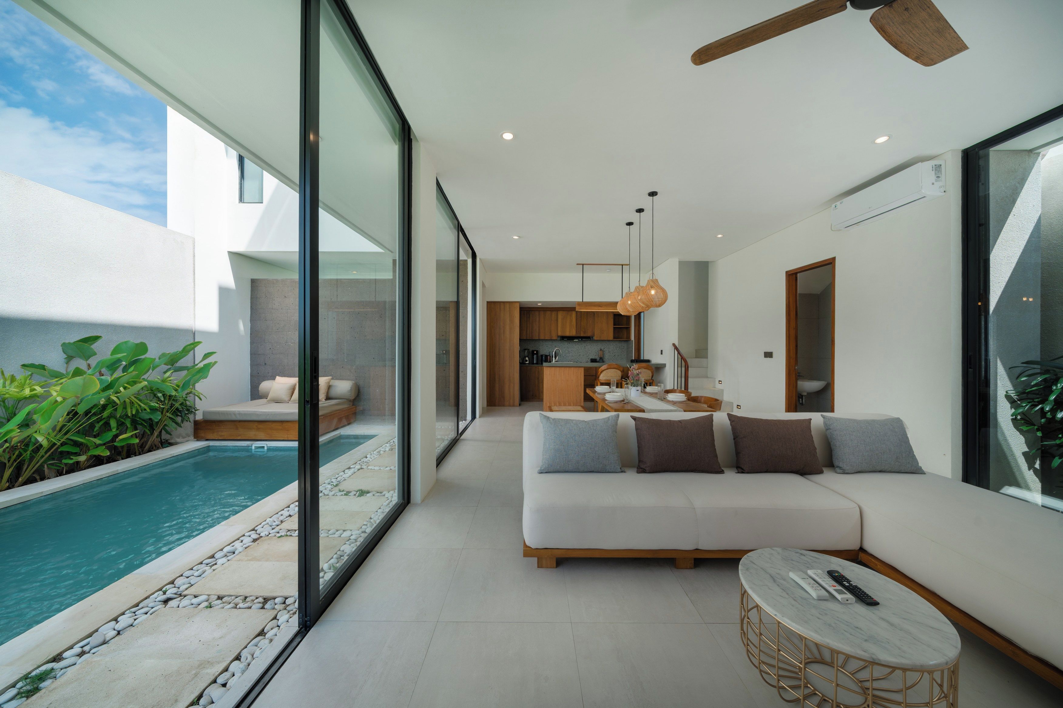 A modern interior with a pool, a sofa, and a dining area.
