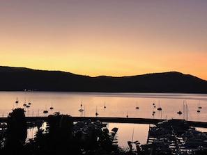 A marina with boats docked, surrounded by hills and a calm body of water during sunset. - Oceanview Villa, Airlie Beach (Airlie Beach)