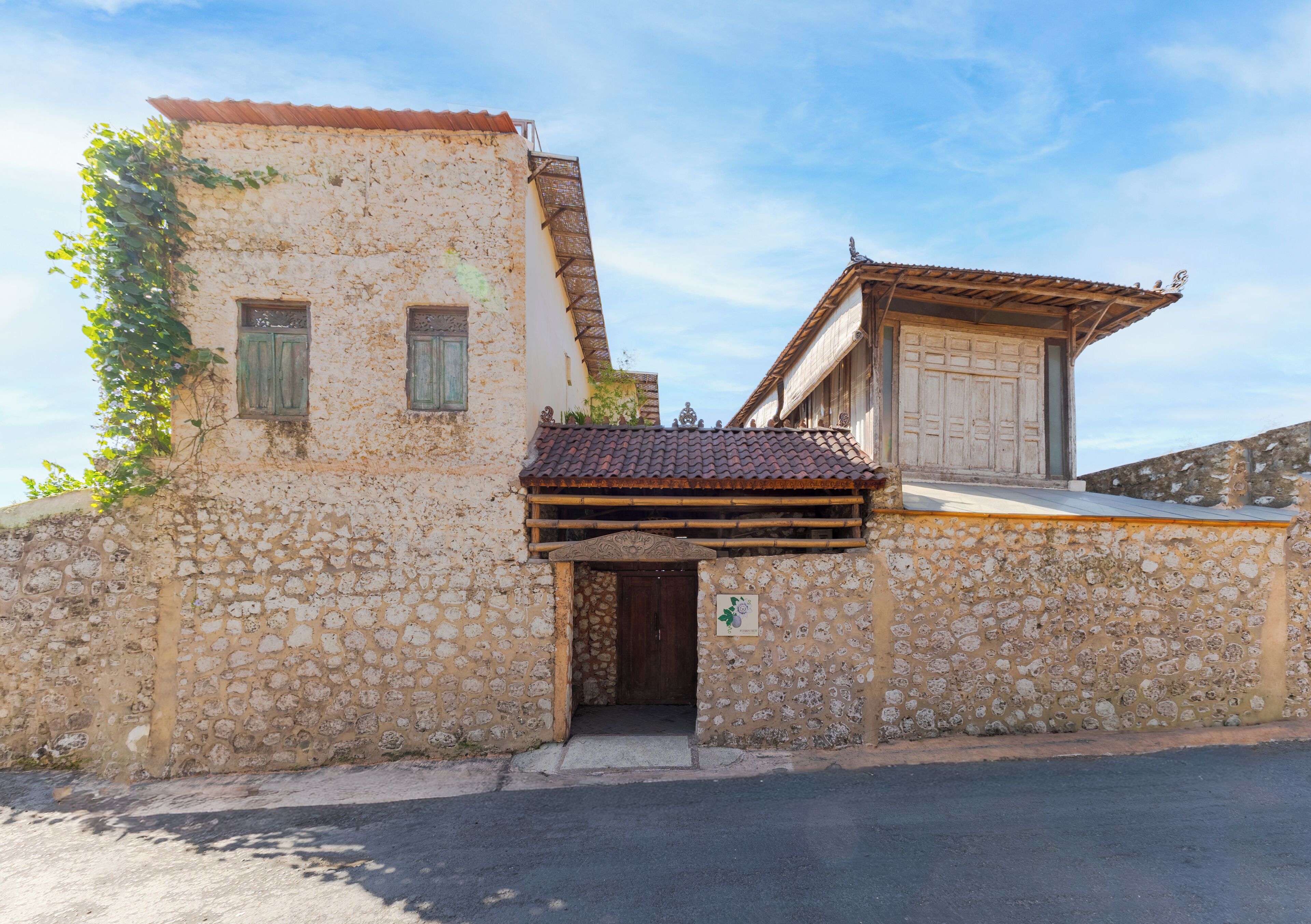 Un edificio de piedra con techo de tejas, una puerta de madera y un pequeño alero.