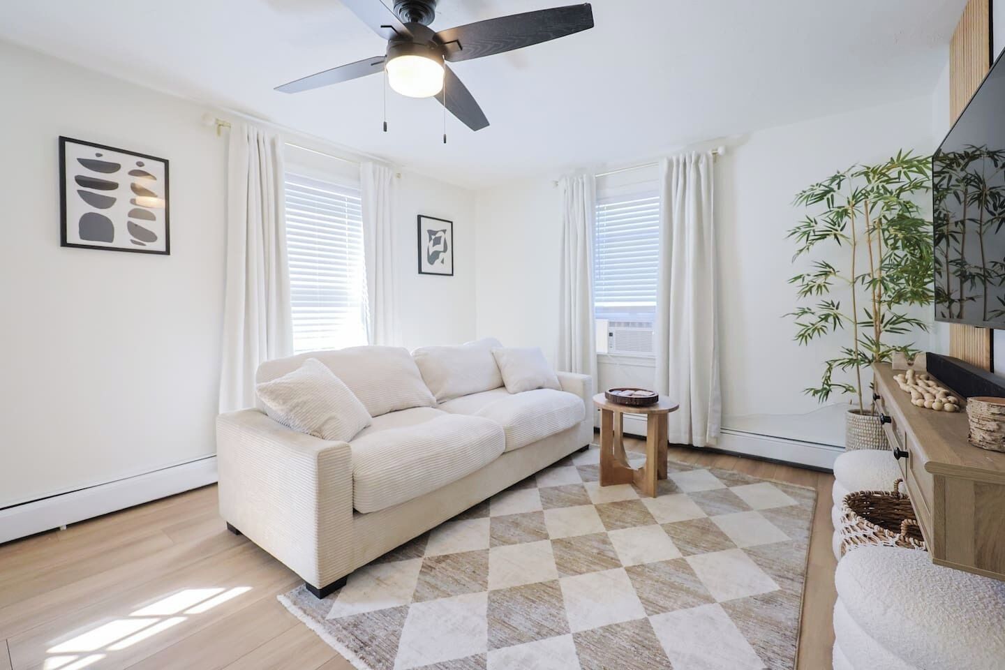 A modern living room with a sofa, a small table, and a ceiling fan.