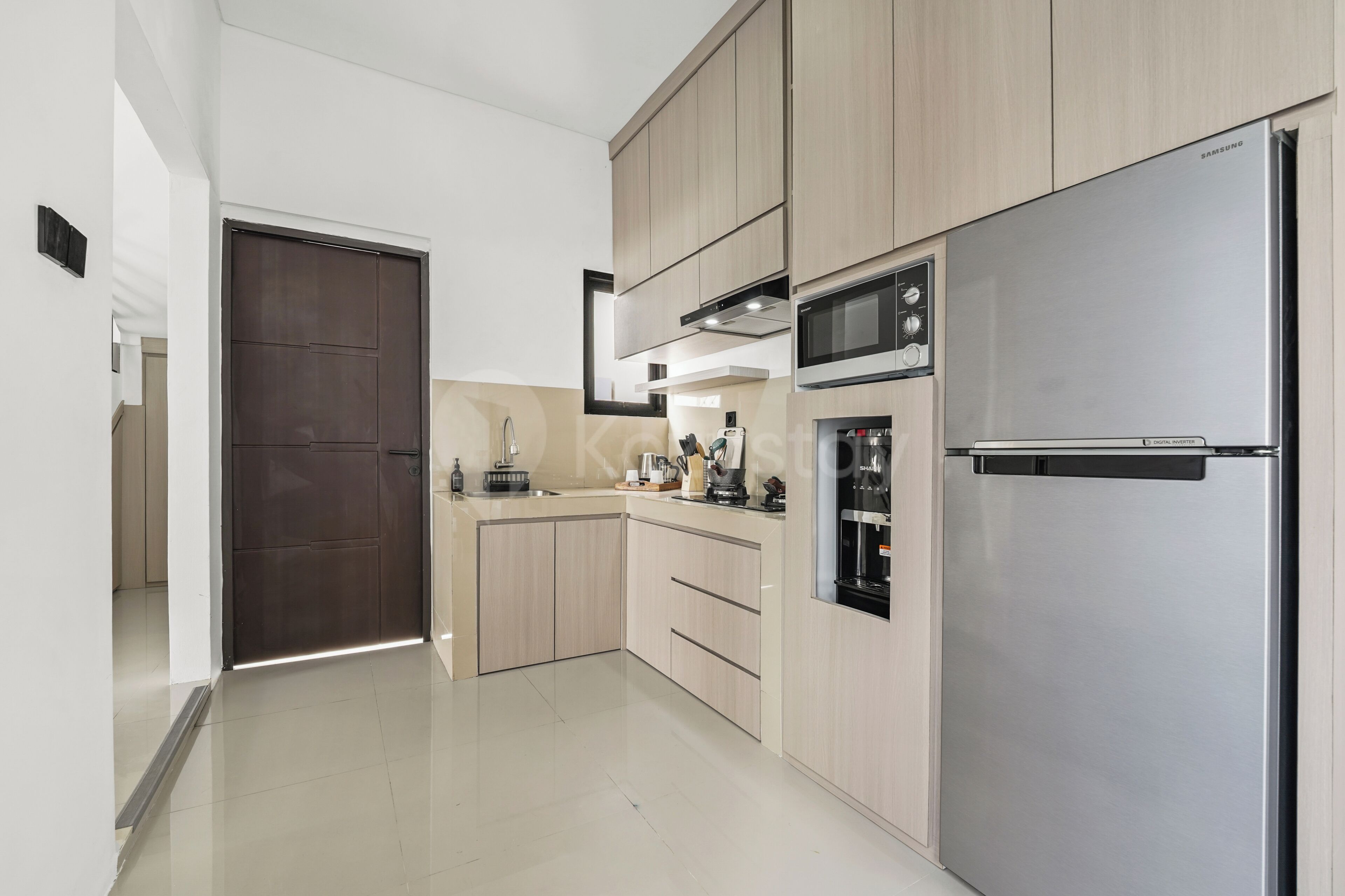Cocina moderna con electrodomésticos de acero inoxidable, armarios de madera y un refrigerador inverter digital.