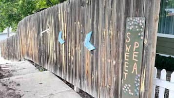 Une clôture en bois agrémentée d’éléments décoratifs et d’une enseigne sur laquelle on peut lire le mot « SWEET ».
