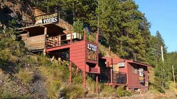 A rustic building with a sign for underground tours and a broken boot gold mine.